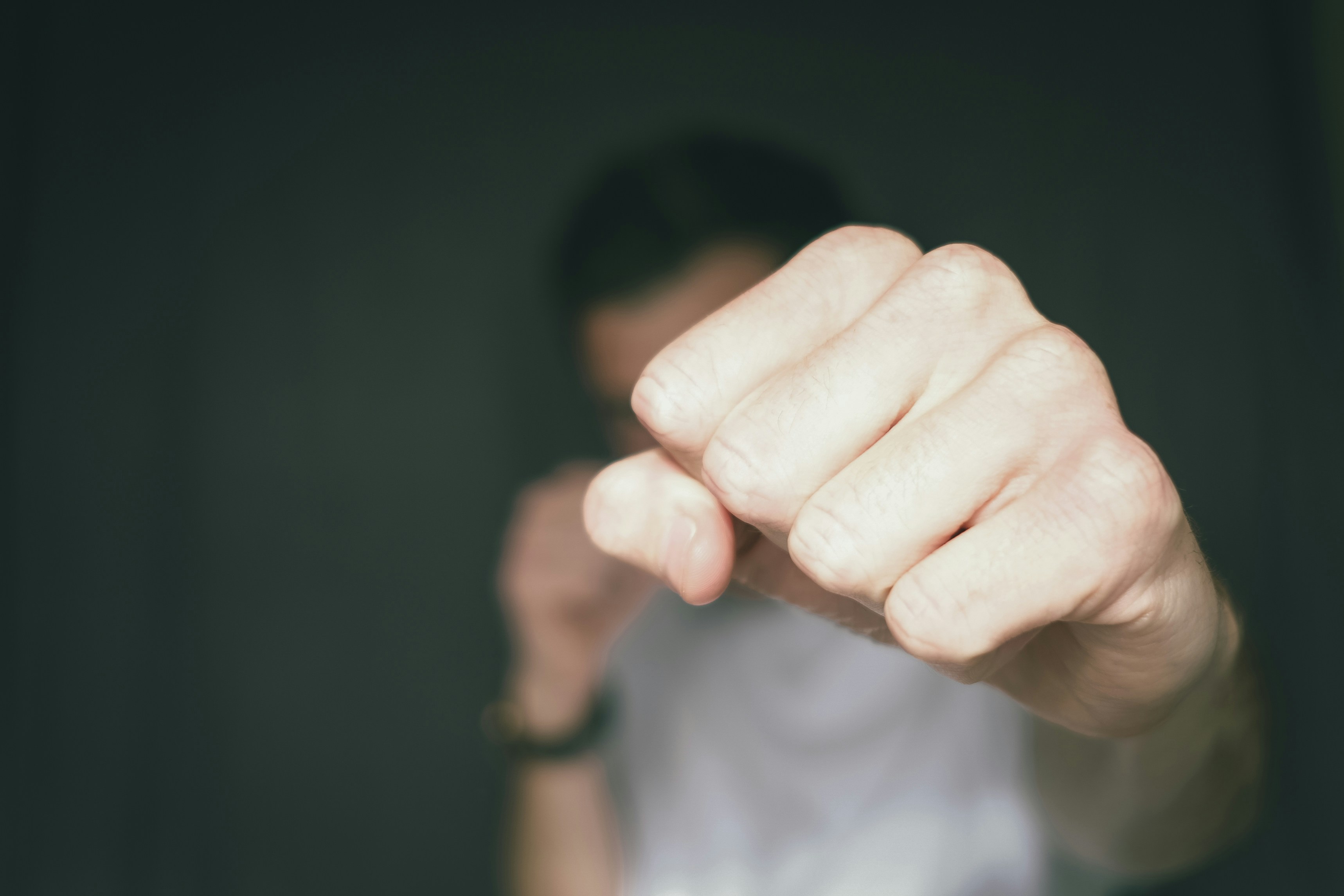 Man throwing a punch, his fist in focus, the rest of him not; image by Dan Burton, via Unsplash.com.