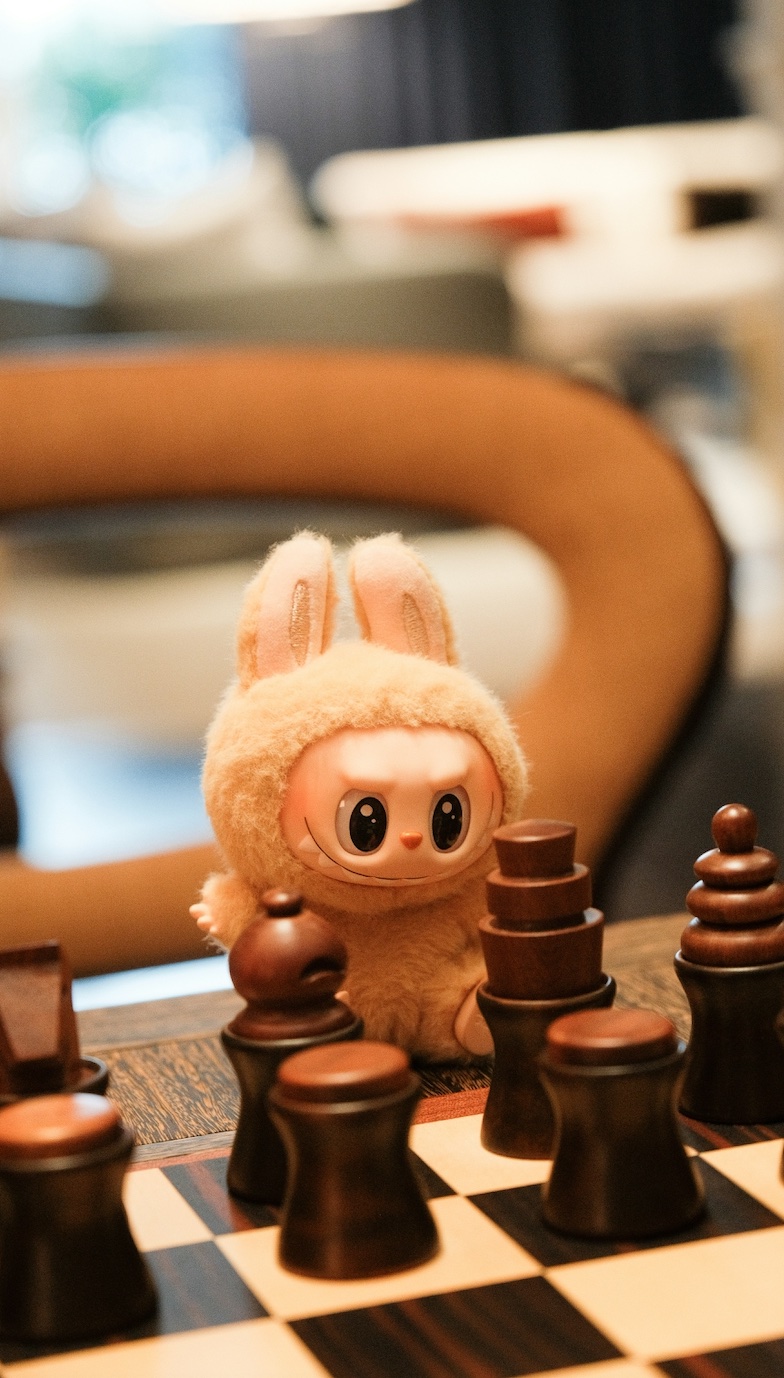 A rabbit toy (Labubu) watches a chess match; image by David Kristianto, via Unsplash.com.