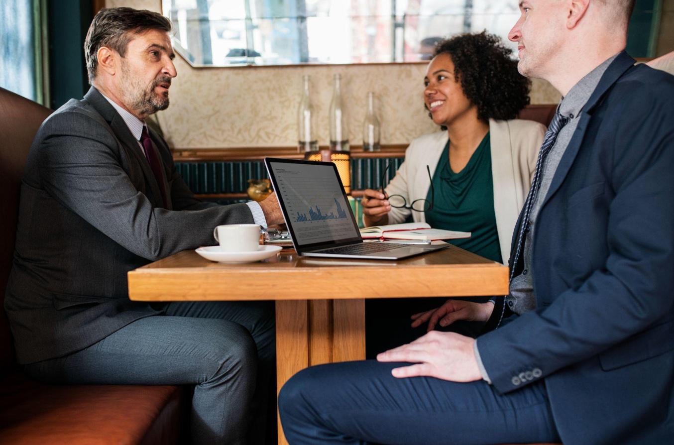 Business meeting with three people at a cafe; image by rawpixel.com, via Magnific.com.