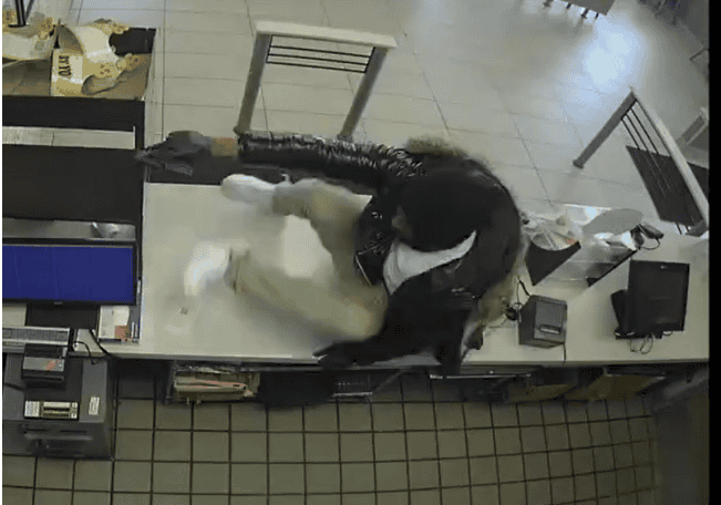 Surveillance photo of Love jumping the counter; photo from press release.
